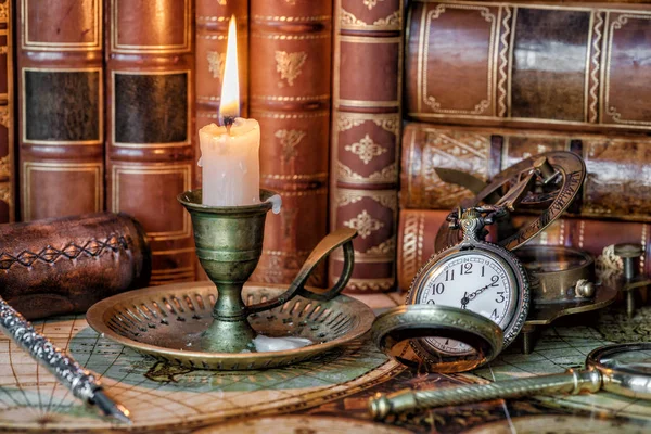 Relógio de bolso, vela acesa e livros antigos Imagens De Bancos De Imagens