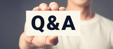 Bir erkek tarafından gösterilen kartta Q & A harfleri (veya sorular ve cevaplar)