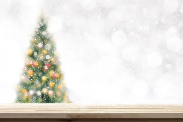 Houten tafelblad op kerstboom achtergrond in sneeuwval wazig — Stockfoto