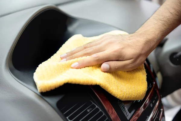 Un hombre limpieza de la mano interior del coche con tela de microfibra — Foto de Stock