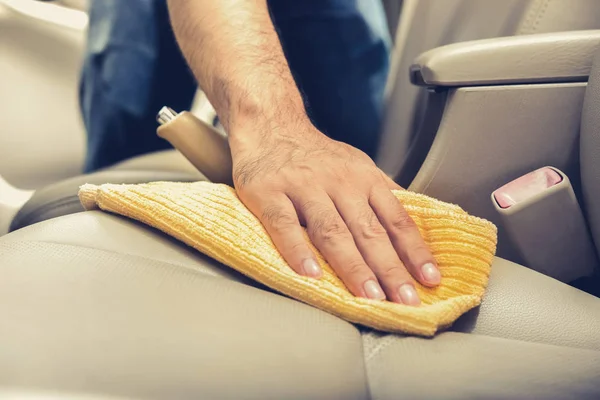 Un hombre limpiando asiento de coche de cuero con tela de microfibra —  Fotos de Stock