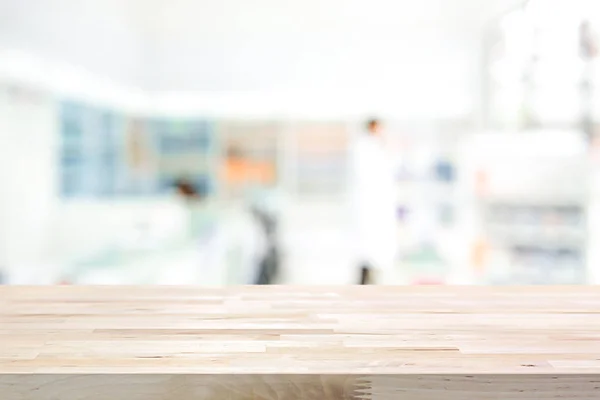 Empty wood counter top on blur pharmacy background — Stock Photo, Image