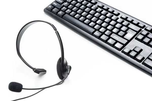 Microphone headset and computer keyboard on the table — Stock Photo, Image