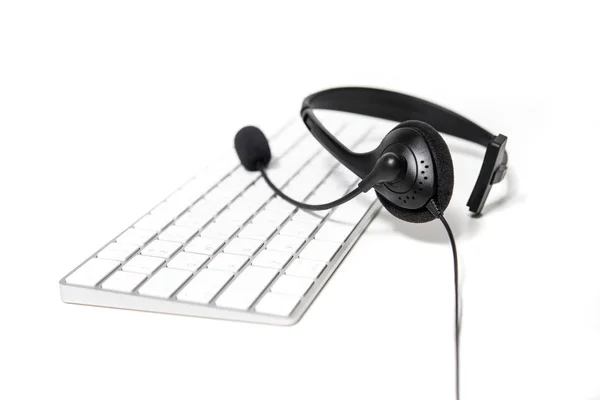 Microphone headset on computer keyboard — Stock Photo, Image