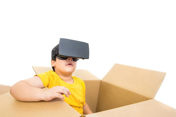 Lindo niño sentado en la caja viendo video en gafas VR — Foto de Stock