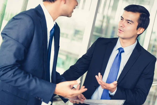 Businessmen discussing work at office building corridor — Stock Photo, Image