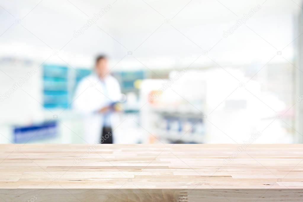 Empty wood counter top on blur pharmacy  background