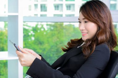 Asya iş kadını ofiste otururken Tablet Pc kullanma