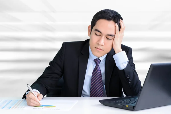 Empresario estresado trabajando en la mesa con la mano en la cabeza — Foto de Stock