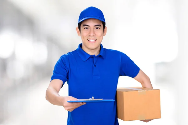 Sorrindo homem entrega dando prancheta enquanto segurando caixa com outra mão — Fotografia de Stock