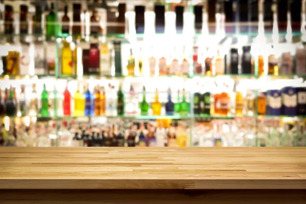 Wood bar top on blur colorful alcohol drink bottle background — Stock Photo, Image