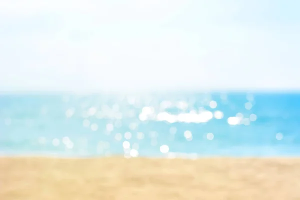 Размытый летний белый песчаный пляж с искрометной морской водой — стоковое фото