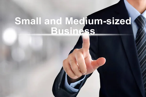 Ділова рука торкається малого та середнього бізнесу ( або SMB ) — стокове фото