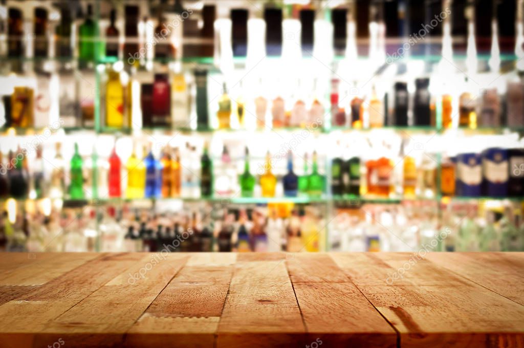 Wood bar top on blur colorful alcohol drink bottle background