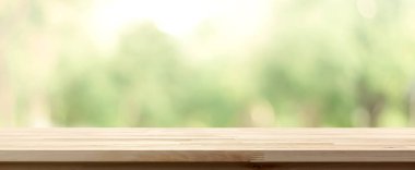 Ahşap masa üstü üzerinde parkta ağaçların yeşil arka plan bulanıklık