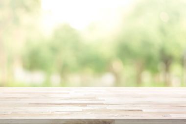 Ahşap masa üstü üzerinde parkta ağaçların yeşil arka plan bulanıklık