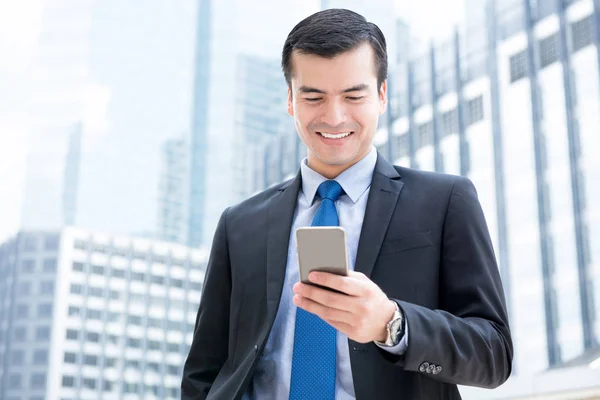Zakenman gebruikend smartphone voor kantoorgebouwen — Stockfoto