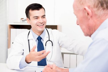 Üst düzey erkek hasta ile danışmanlık doktor gülümseyen