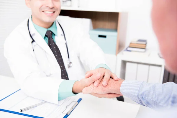 Doctor holding senior male patient hand — Stock Photo, Image