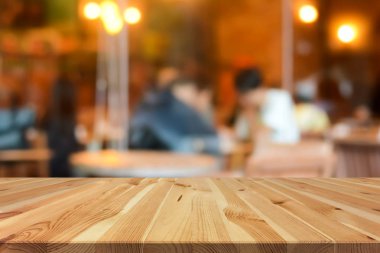 Ahşap masa üstü üzerinde bazı insanlar ile kahvehane iç arka plan bulanıklık 