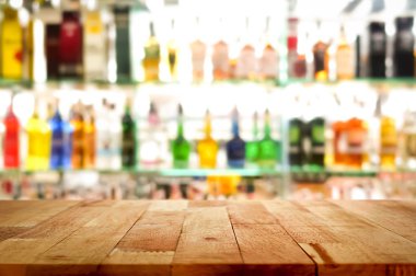 Ahşap bar üstüne renkli alkol içki şişesi arka plan bulanıklık