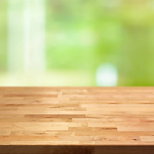 Mesa de madera sobre fondo abstracto verde borroso — Foto de Stock