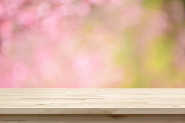 Meja kayu atas pada latar belakang kabur bunga ceri merah muda mekar — Stok Foto