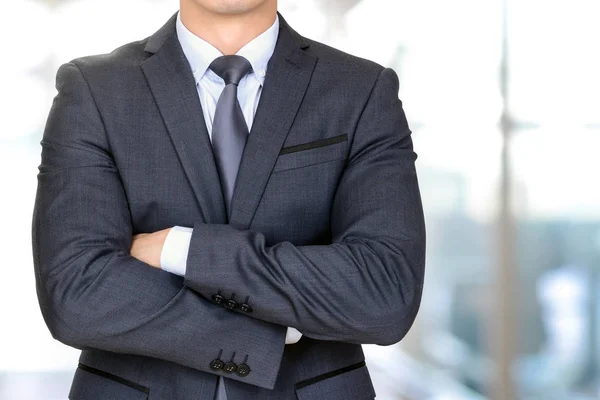 Anonymous businessman in dark gray suit crossing his arms — Stock Photo, Image