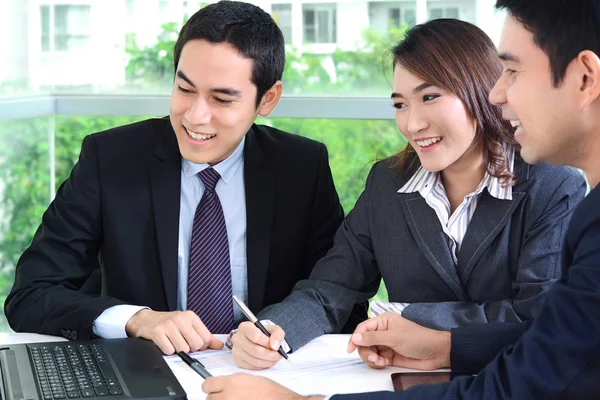 Os empresários asiáticos discutindo e sorrindo em uma reunião — Fotografia de Stock