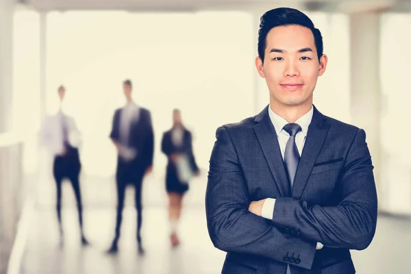 Sonriente asiático hombre de negocios cruzando sus brazos — Foto de Stock