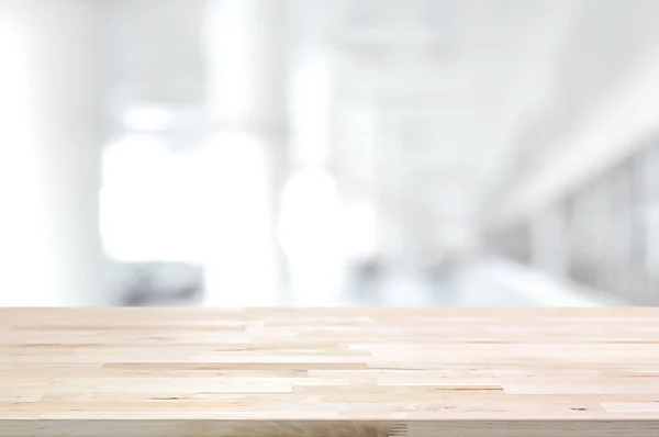 Dřevo stolu na rozmazané bílé šedé pozadí výstavby haly — Stock fotografie