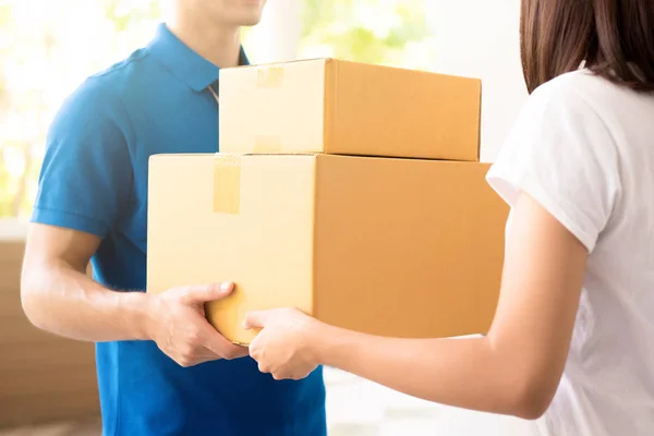 Kvinna tar emot paket från courier — Stockfoto