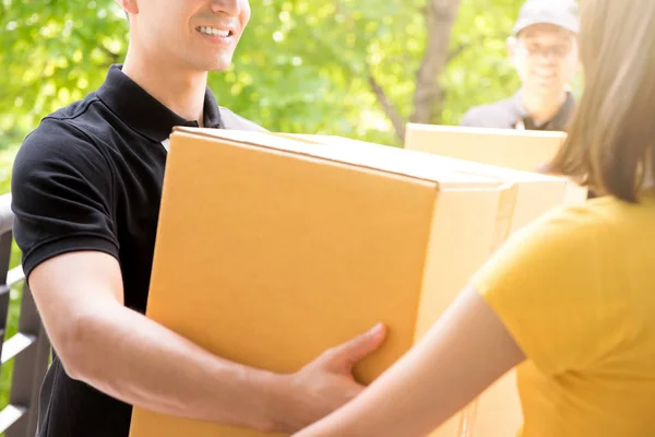 Delivery team delivering parcels to a woman — Stock Photo, Image