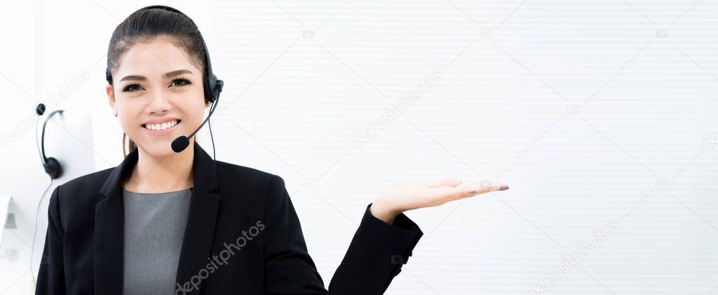 Asian businesswoman as an operator in call center making open hand (palm) gesture