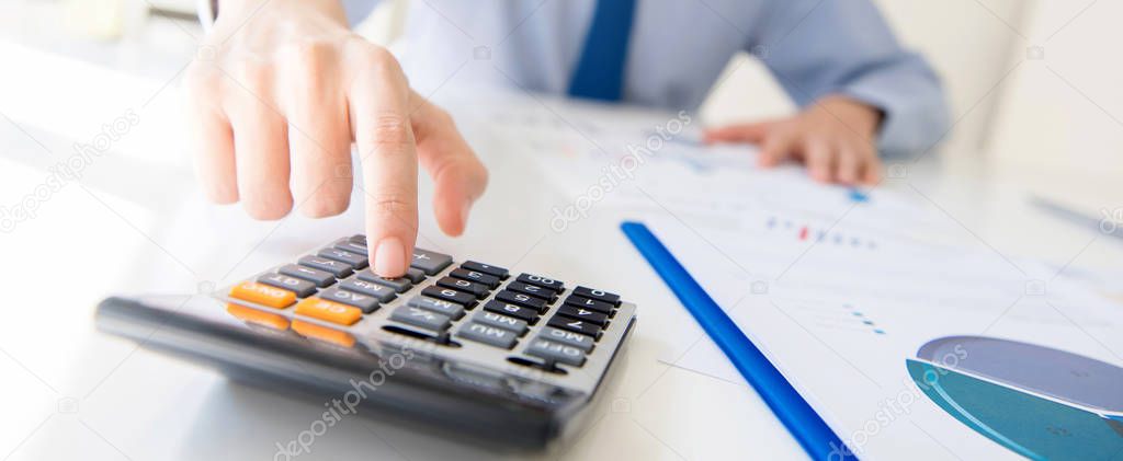 Businessman pressing calculator button