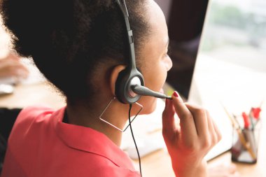 Ofiste çalışan mikrofon kulaklık giyen işkadını 
