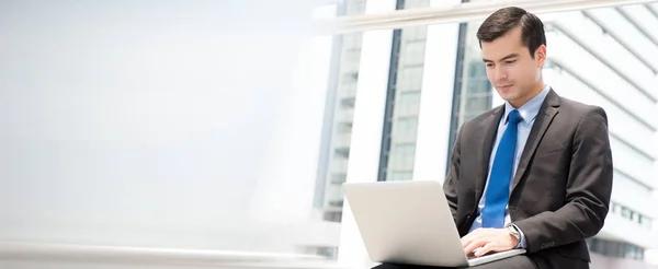 Бізнесмен, використовуючи ноутбук, сидячи на відкритому повітрі — стокове фото