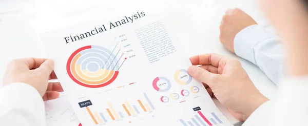 Podnikatel na papíře při pohledu na graf finanční analýzy — Stock fotografie