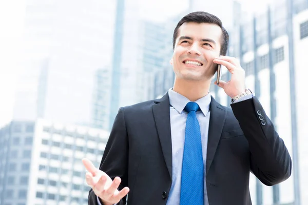 Empresario llamando en smartphone con gesto de mano en la oficina borrosa —  Fotos de Stock