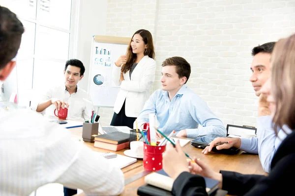 Young interracial business people listening to their colleague in the meeting — Stock Photo, Image