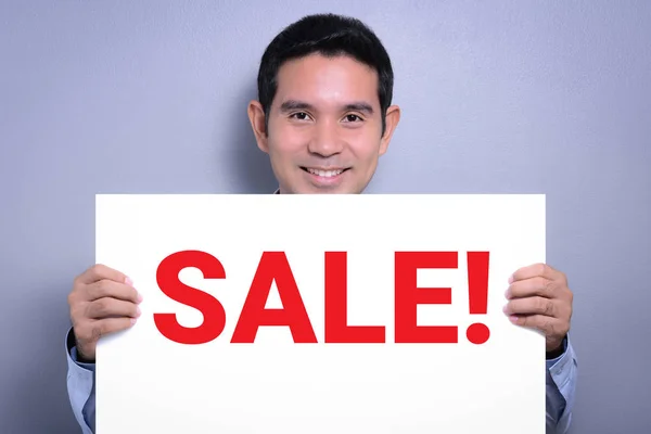 Smiling man holding SALE! sign — Stock Photo, Image