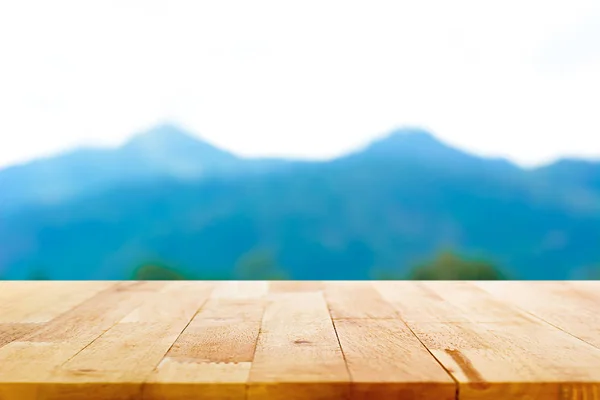 Houten tafelblad op berg achtergrond wazig — Stockfoto