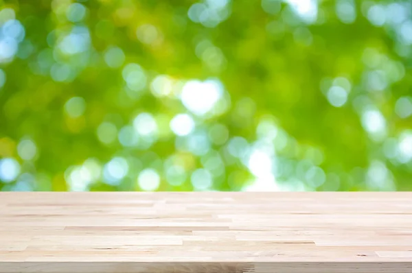 Dřevo stolu na abstraktní pozadí zelené přirozený bokeh — Stock fotografie