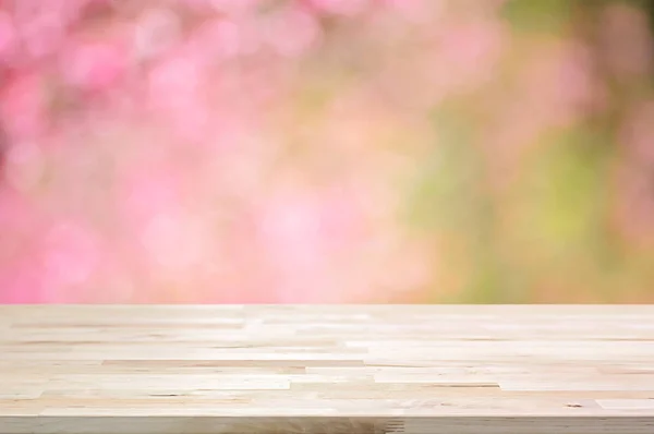 나무 테이블 상단에 분홍색 벚꽃 꽃의 배경을 흐리게 — 스톡 사진