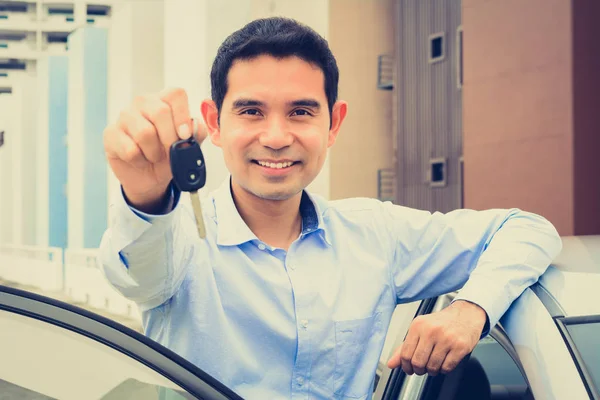 Lächeln asiatischer Mann zeigt Autoschlüssel (Gesicht fokussiert) — Stockfoto