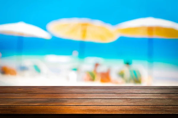 Mesa de madera sobre fondo borroso de playa, fondo de vacaciones de verano — Foto de Stock