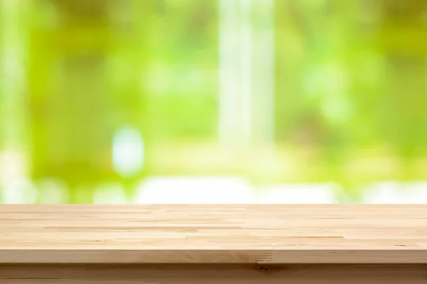 Holz Tischplatte auf verschwommenem grünen abstrakten Hintergrund — Stockfoto