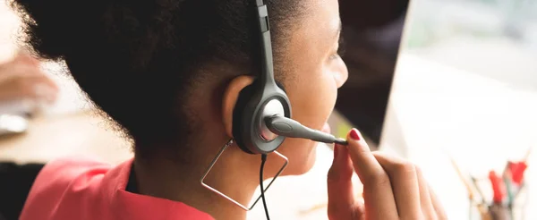 Achteraanzicht van Afro zakenvrouw microfoon hoofdtelefoon dragen op het werk — Stockfoto