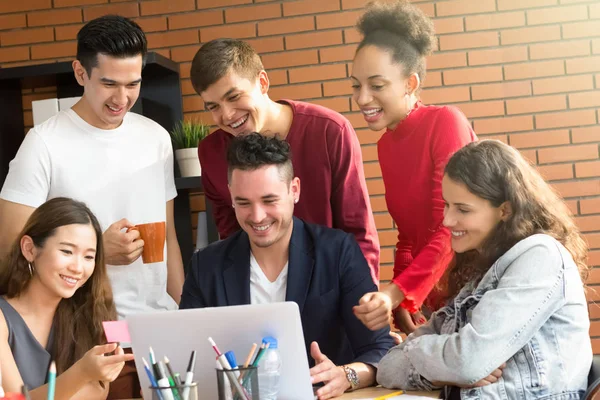 Group of casual mixed race people looking at laptop computer discussing work — Stock Photo, Image