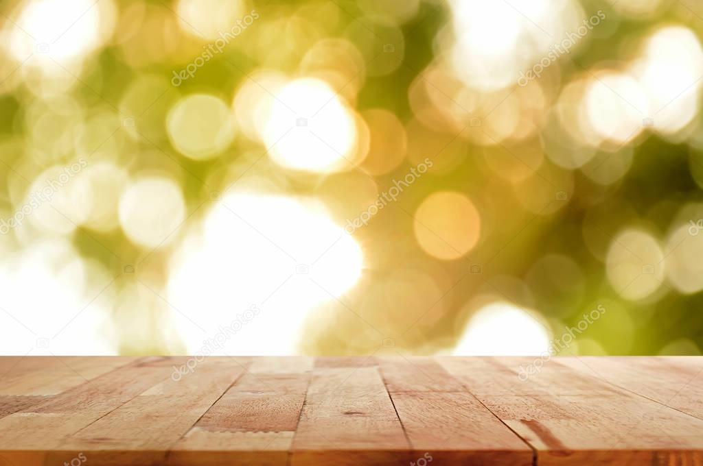 Wood table top on shinny sunlight natural green bokeh abstract background